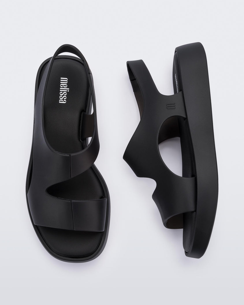 A top and side view of pair of black Melissa Franny sandals with straps.