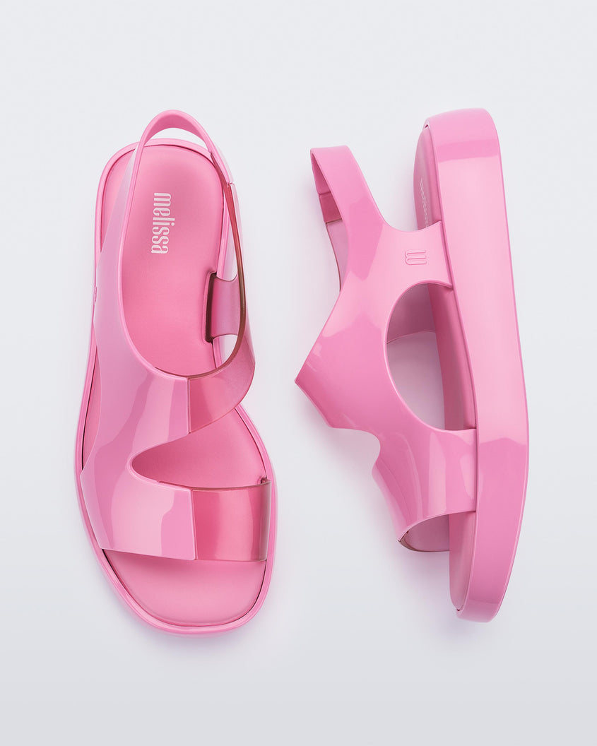 A top and side view of a pair of pink Melissa Franny sandals with straps.