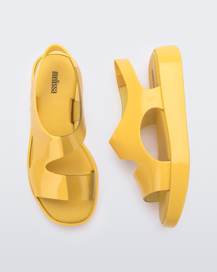 A top and side view of a pair of yellow Melissa Franny sandals with straps.