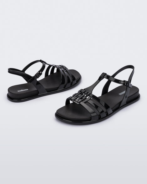 Front and back view of a pair of Melissa Party sandals in black with back ankle strap and buckle closure