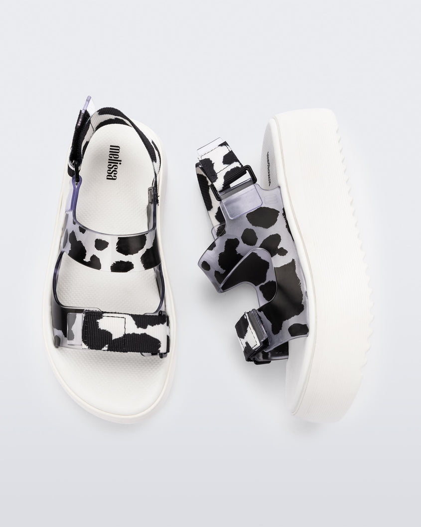 Top and side view of a pair of white Melissa Brave Papete platform sandals with black spotted straps.