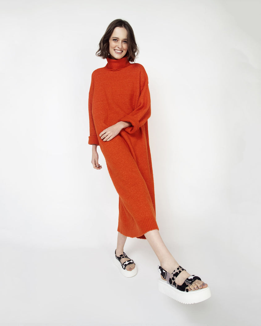 A model posing wearing a pair of white Melissa Brave Papete platform sandals with black spotted straps.