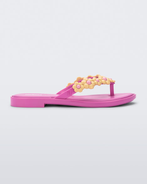 Side view of a pink Melissa Spring Flip Flop with pink and yellow flowers on them.