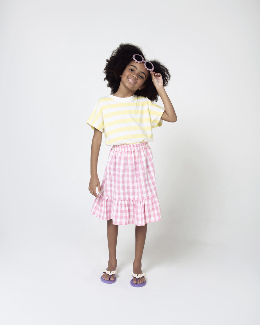 A model posing for a picture wearing a pair of lilac Mini Melissa Spring Flip Flops with white and yellow flowers.
