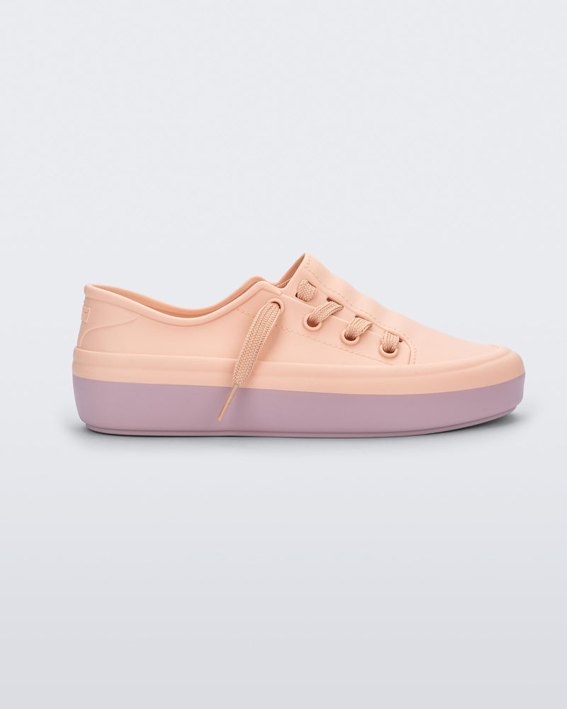 Side view of a pink Melissa Ulitsa sneaker with a pink base and laces.