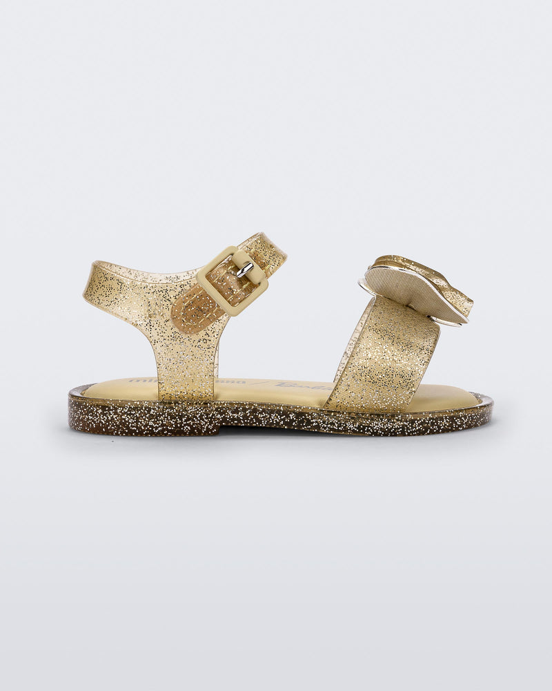 Side view of a yellow glitter Mini Melissa Mar Sandal with a heart shaped bow and buckle.