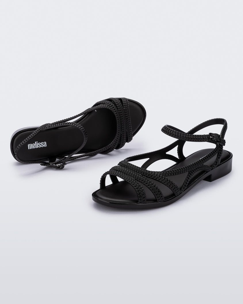 A top and side view of a pair of black Melissa Femme Classy sandals with straps and a woven design.
