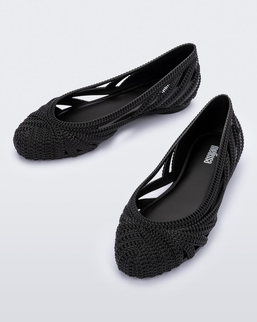 A top view of a pair of black Melissa Femme Classy flats with a woven design.