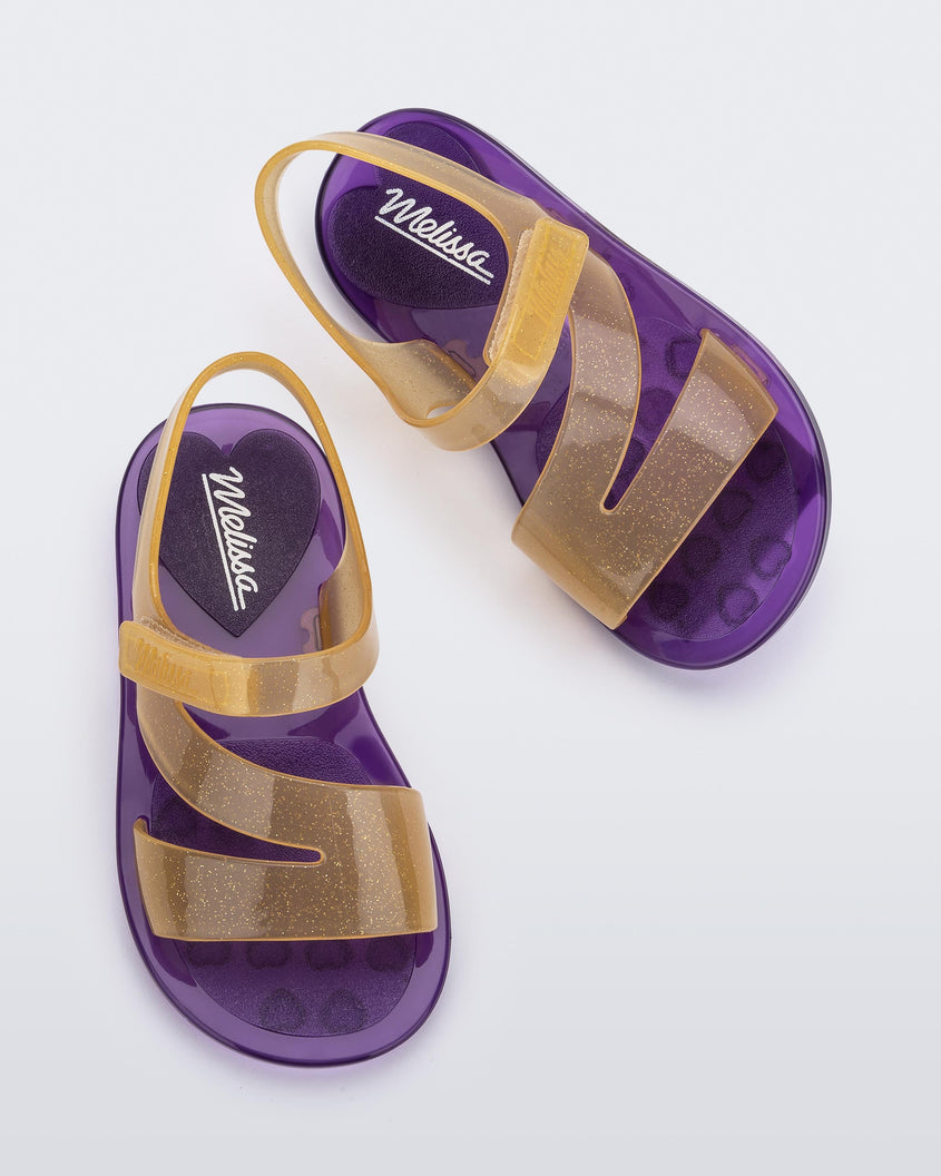 Top view of a pair of purple/yellow Mini Melissa The Real Jelly Paris sandals with three front yellow straps, a back ankle strap and a purple sole.