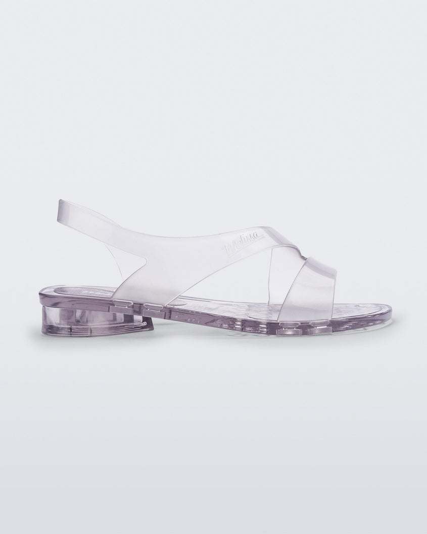 Side view of a clear Melissa The Real Jelly Paris sandal with two front straps and an ankle strap.