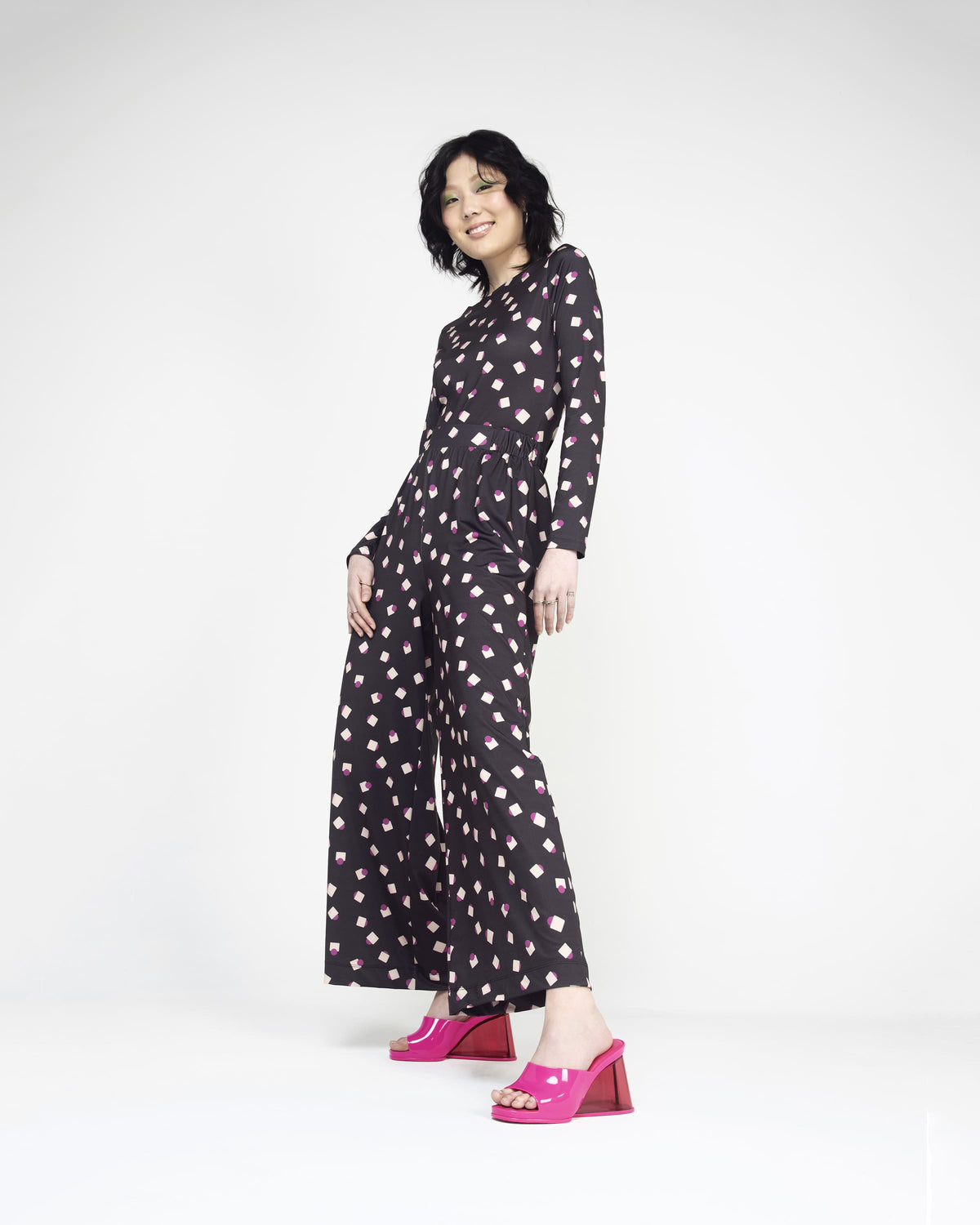 A model posing for a picture wearing a pair of pink Melissa's Darling heels with clear soles.