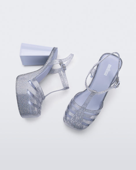 A top and side view of a glitter clear Melissa Party Heel with several straps and a closed toe front.