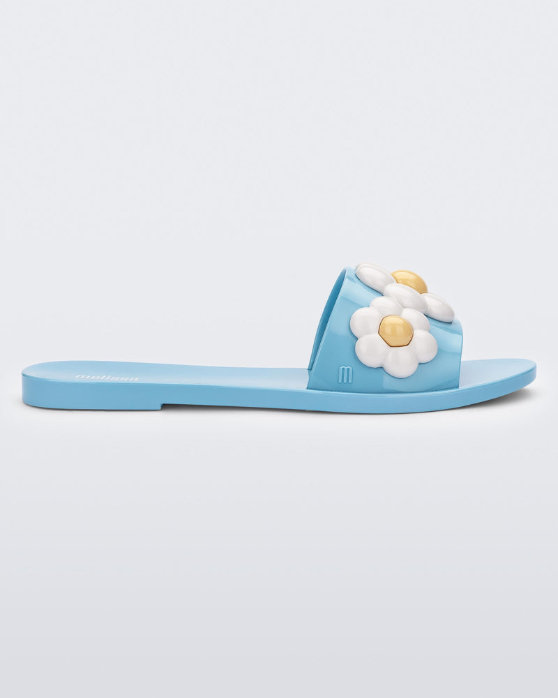 Side view of blue Melissa Babe Spring slide with white flowers.