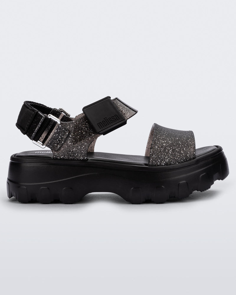 Side view of a black/glitter black platform Melissa Kick Off Sandal with two glitter straps.