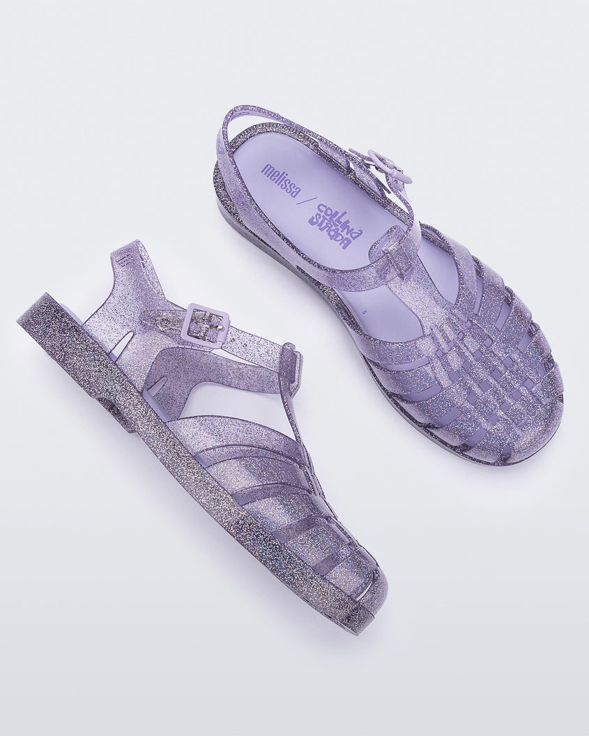 A top and side view of a pair of glitter lilac Melissa Possession sandals with several straps and a closed toe front.
