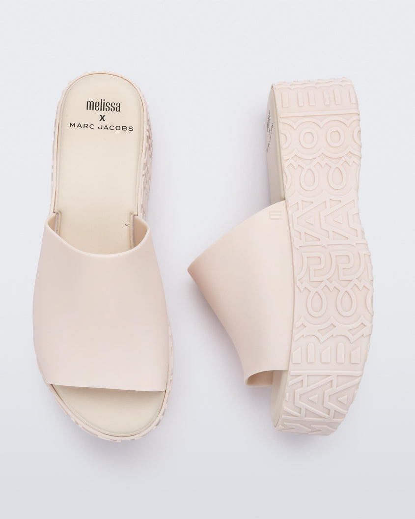 A top and side view of a pair of beige Melissa Becky platform slides with the Marc Jacob's logo across the sole.