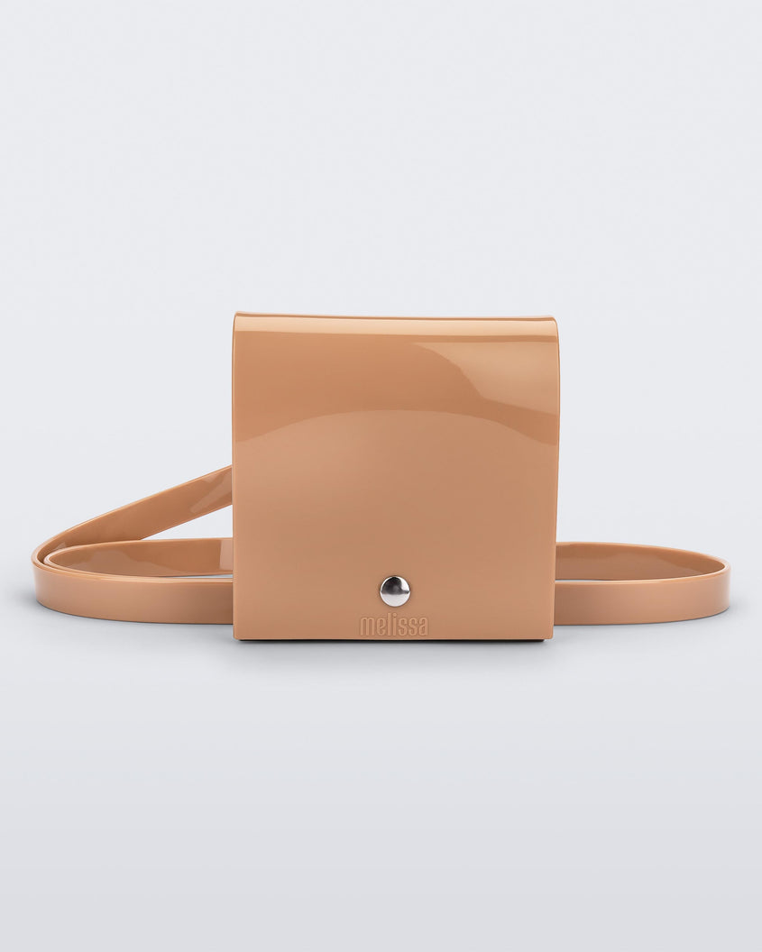 A front view of a beige Melissa Like It purse with a silver button and a Melissa logo on the front.
