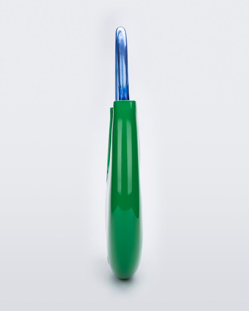 Side view of a Green/Blue Melissa Moon Bag with a crescent shaped green bag base and a blue beige top strap.