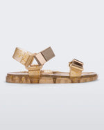 Side view of a Melissa Wide Papete sandal with transparent beige glitter sole and beige velcro straps.
