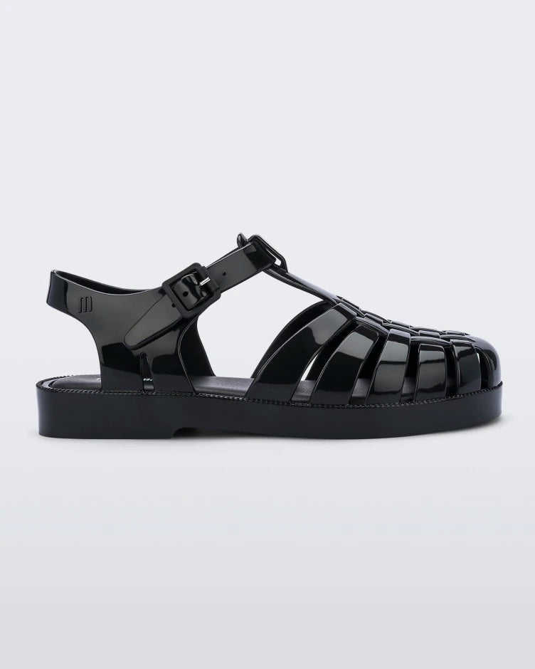 An outter side view of a black Mini Melissa Possession sandal with several straps and a black base.