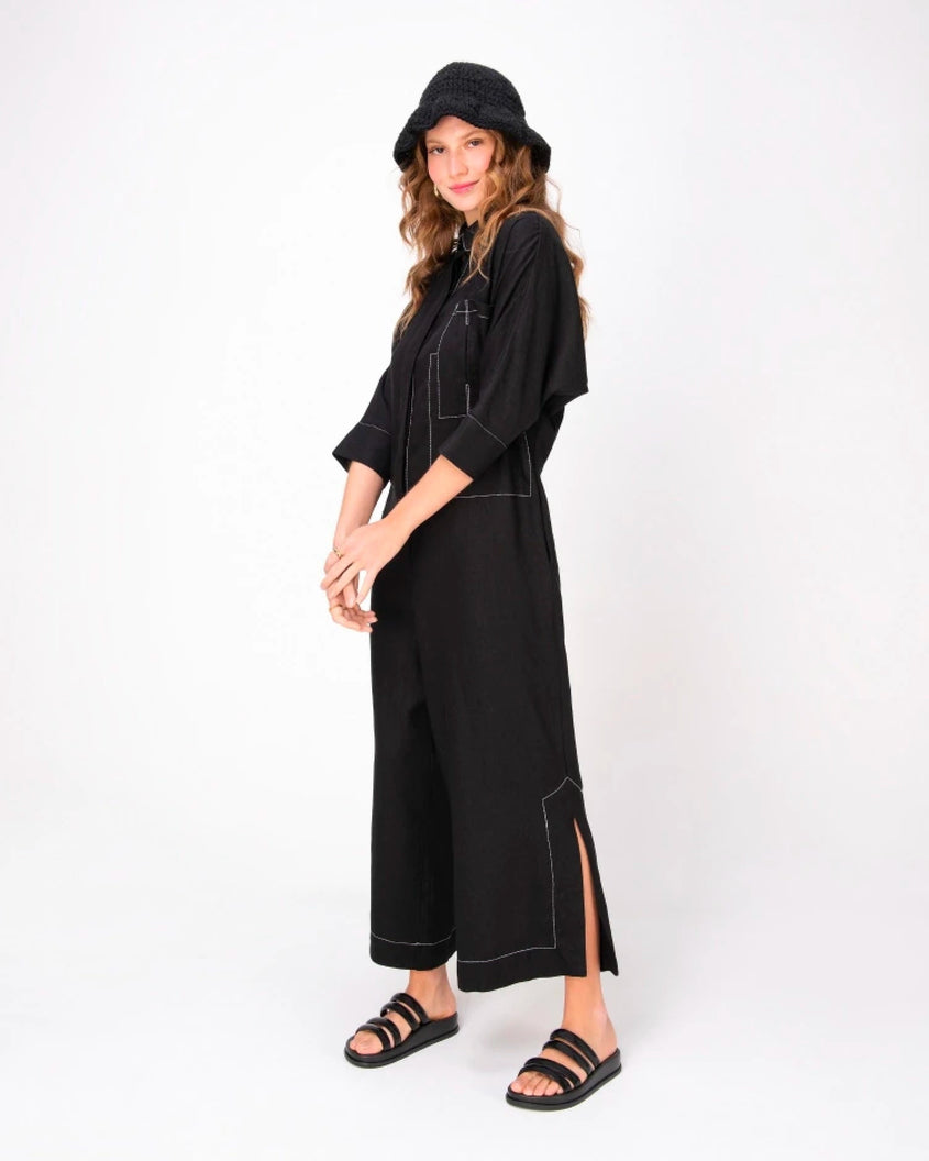 A model in a black dress wearing a pair of Black Melissa Soft Wave Slides with 4 front straps.