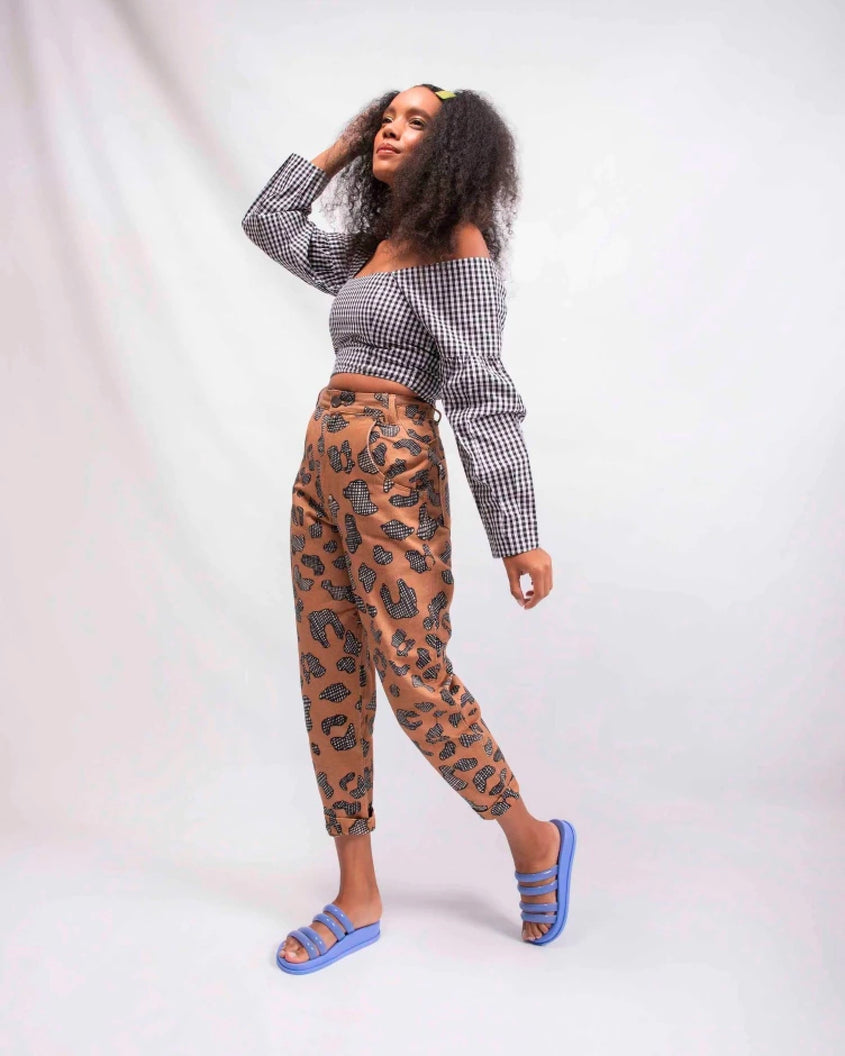 A model posing for a picture in a black gingham top, orange patterned pants and a pair of Blue Melissa Soft Wave Slides with 4 front straps.