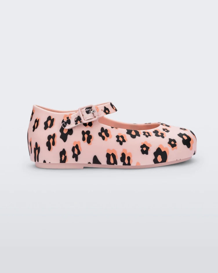 Side view of a Mini Melissa beige / black Dora flat with black and orange flower print.