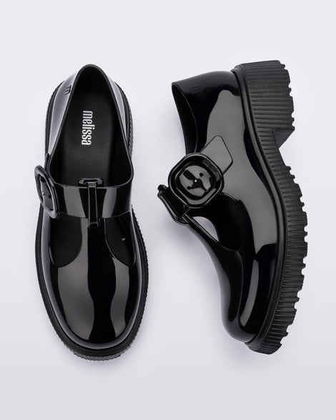Top and side view of a pair of black Melissa Jackie loafers with two cut outs and a buckle detail strap.
