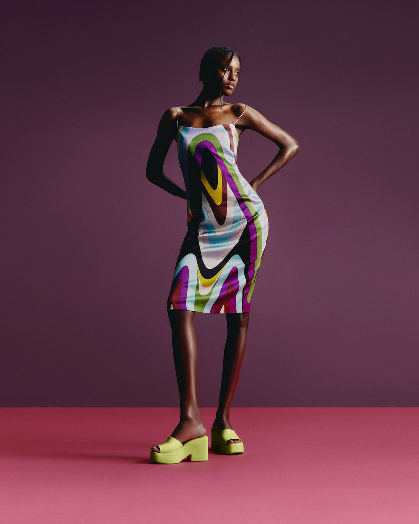 A model posing wearing a pair of Melissa Posh platform slides in Yellow