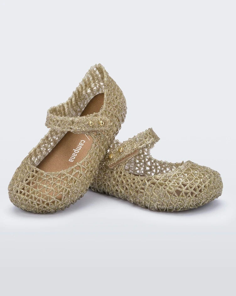 Angled view of a pair of Mini Melissa Campana flats in gold for baby with an open woven texture.