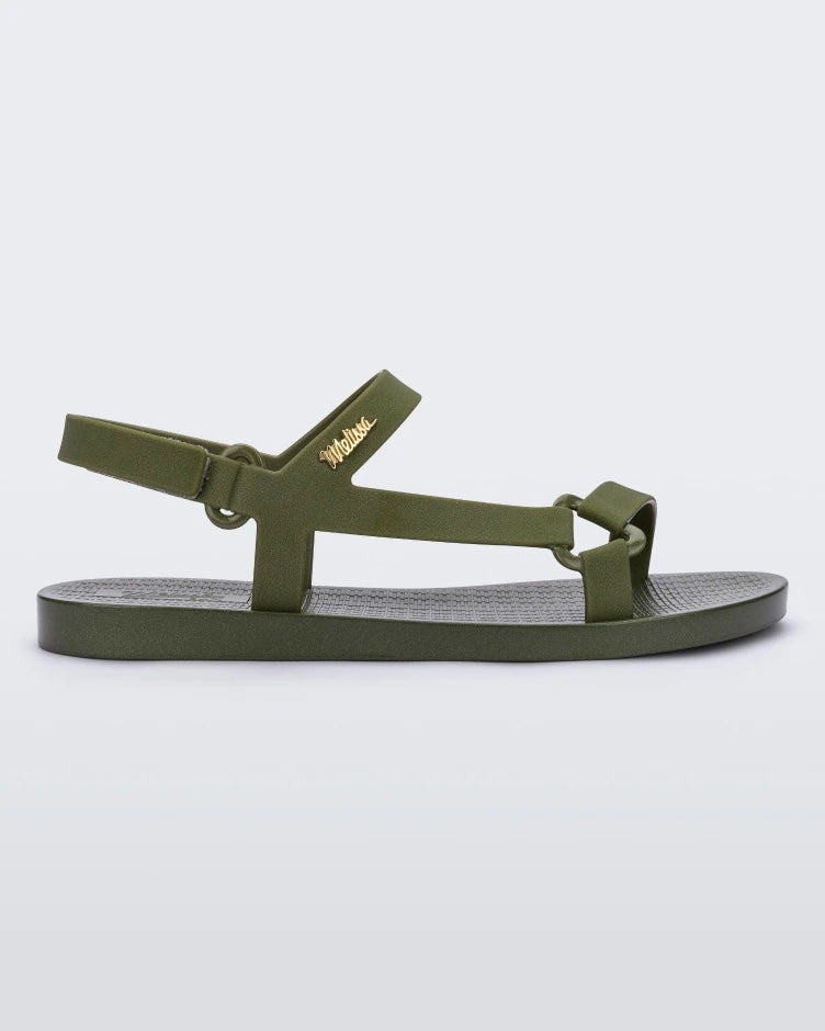 Side view of a green metallic Melissa Sun Downtown sandal with a front and ankle strap joined together by a vertical strap and a triangle buckle.