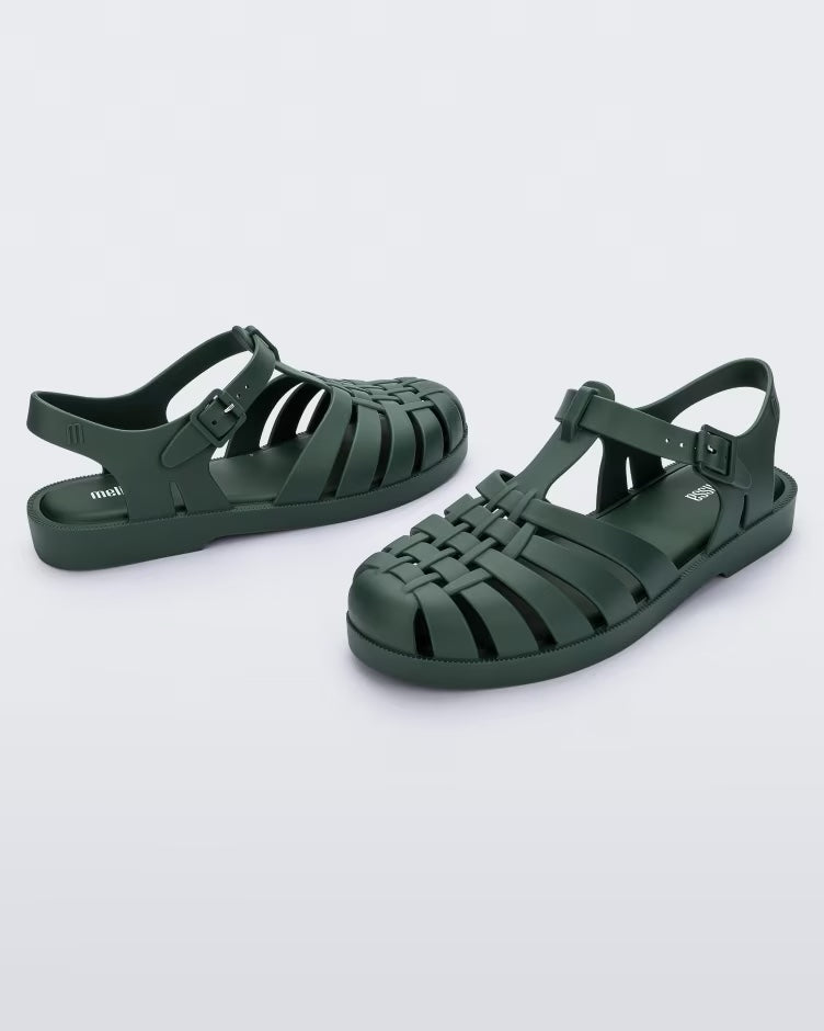 An angled front and side view of a pair of dark green Melissa Possession sandals with several straps and a closed toe front.