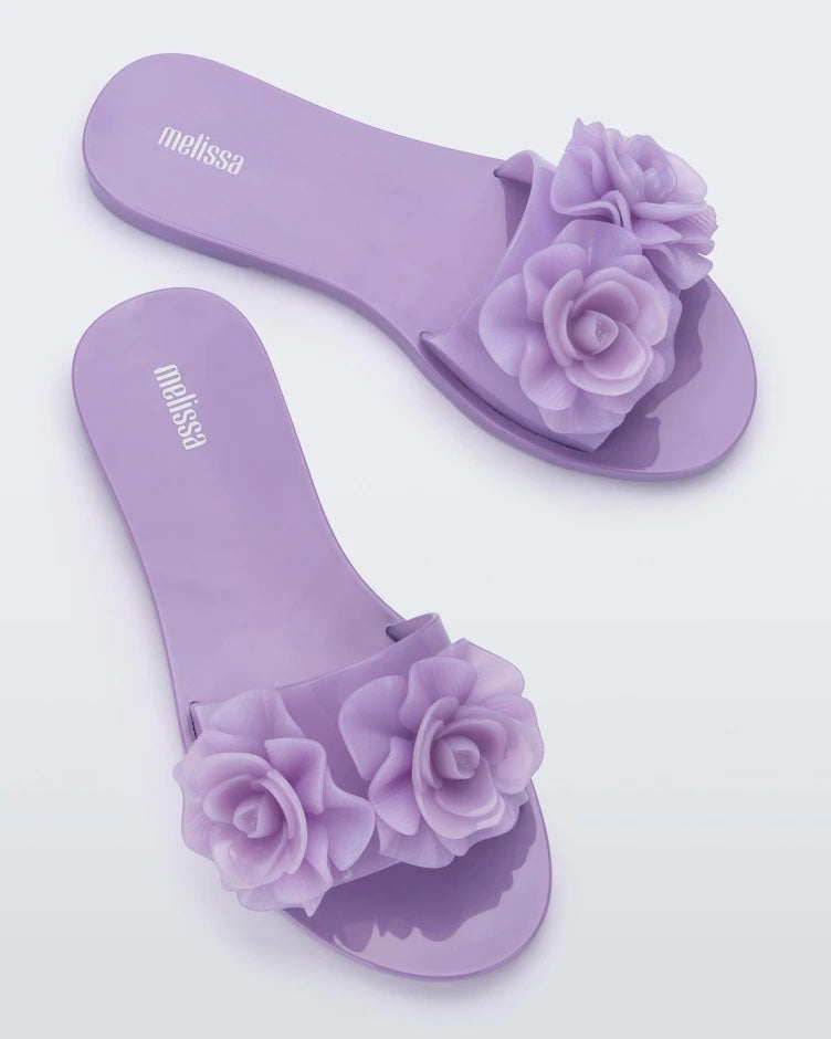 Top view of a pair of lilac Melissa Babe Garden slides with two flowers on the front strap.