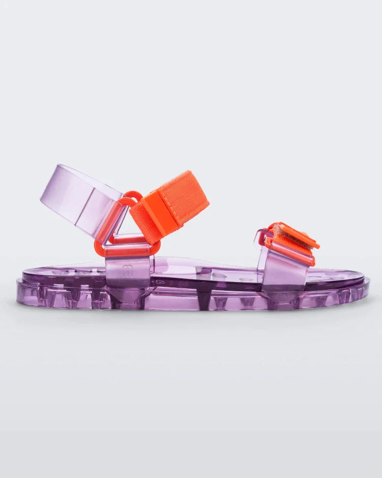 Side view of a Melissa Wide Papete sandal with transparent Purple sole and orange velcro straps.