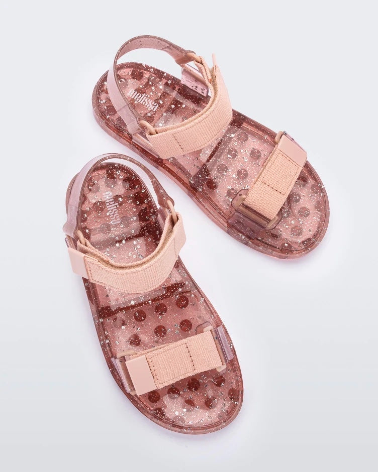 Top view of a pair of Melissa Wide Papete sandal with transparent pink glitter sole with pink velcro straps