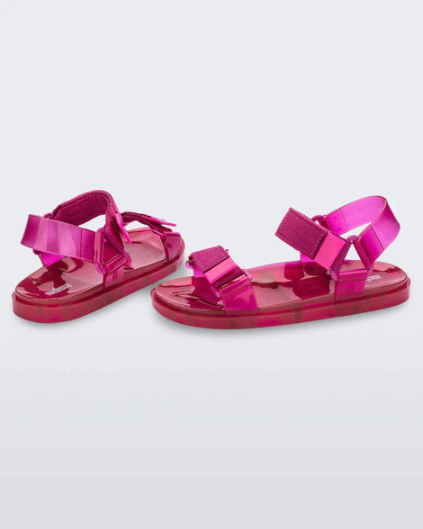 Angled view of a pair of Melissa Wide Papete sandals in pink with velcro ankle and front straps.