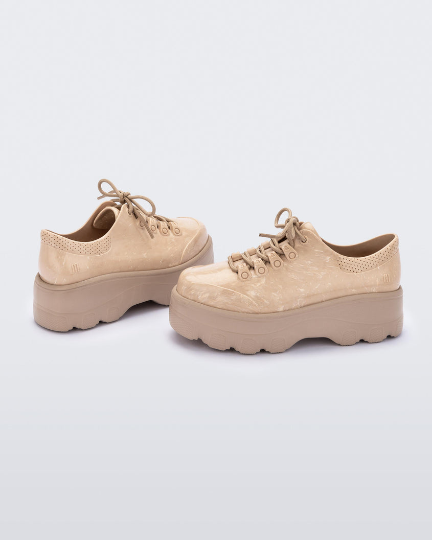 An angled side view of a pair of beige platform Melissa Kick Off Sneakers with laces.