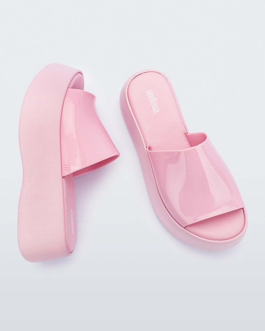 Top and side view of a pair of pink Melissa Becky platform slides.