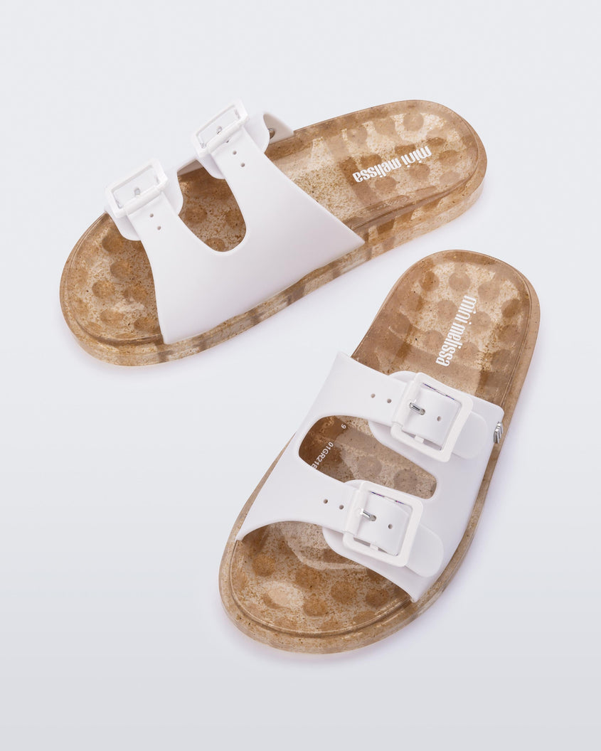 Top view of a pair of Beige Mini Melissa Wide Slides with a white top with two white buckles and a beige sole.