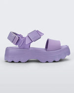 Side view of the Melissa Kick Off platform sandal in lilac. The sandal has an ankle strap with a plastic clasp closure on the front ankle side, additional velcro adjustable strap is on the back of the ankle strap.