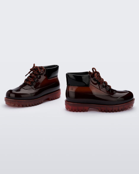 A side view of a pair of translucent brown / black Melissa Ares combat boots with a translucent brown/black base, brown patterned laces, black top back and translucent brown sole.