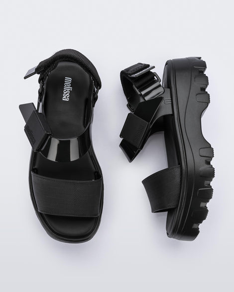 A top and side view of a pair of black platform Melissa Kick Off Sandals with two straps.