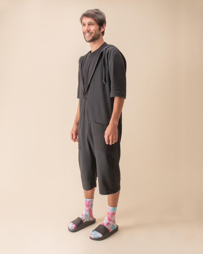 A model standing and wearing a pair of black Melissa Beach slides with tie dye socks