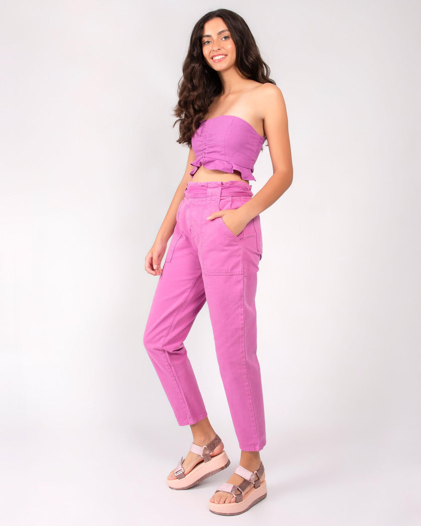 A model in a pink top, bottoms and pair of pink Melissa Papete Platform sandals with glitter straps and a pink and glitter sole.
