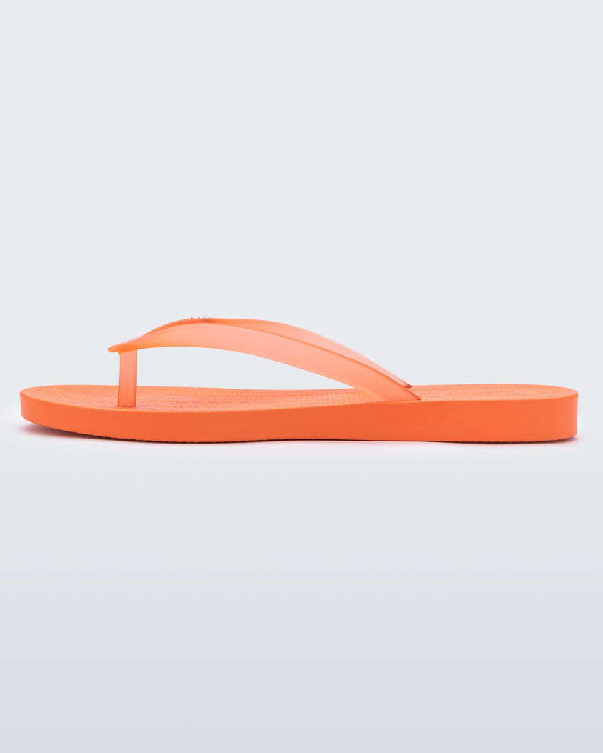 An inner side view of an orange Melissa Sun Venice flip flop with