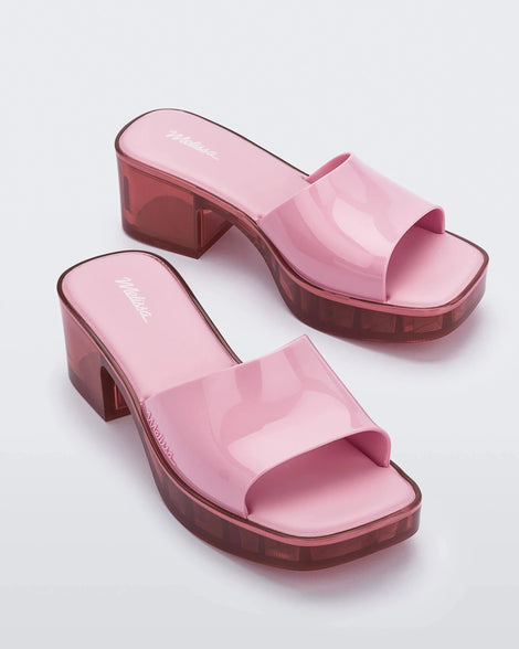 Additional angled view of a pair of Melissa Shape slides with transparent pink platform heel and a pink wide front strap.
