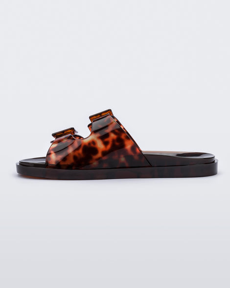 Inner side view of a Melissa Wide slide sandal with brown sole and brown tortoise colored straps