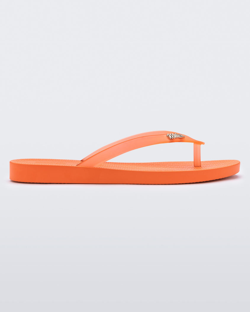 An outter side view of an orange Melissa Sun Venice flip flop with
