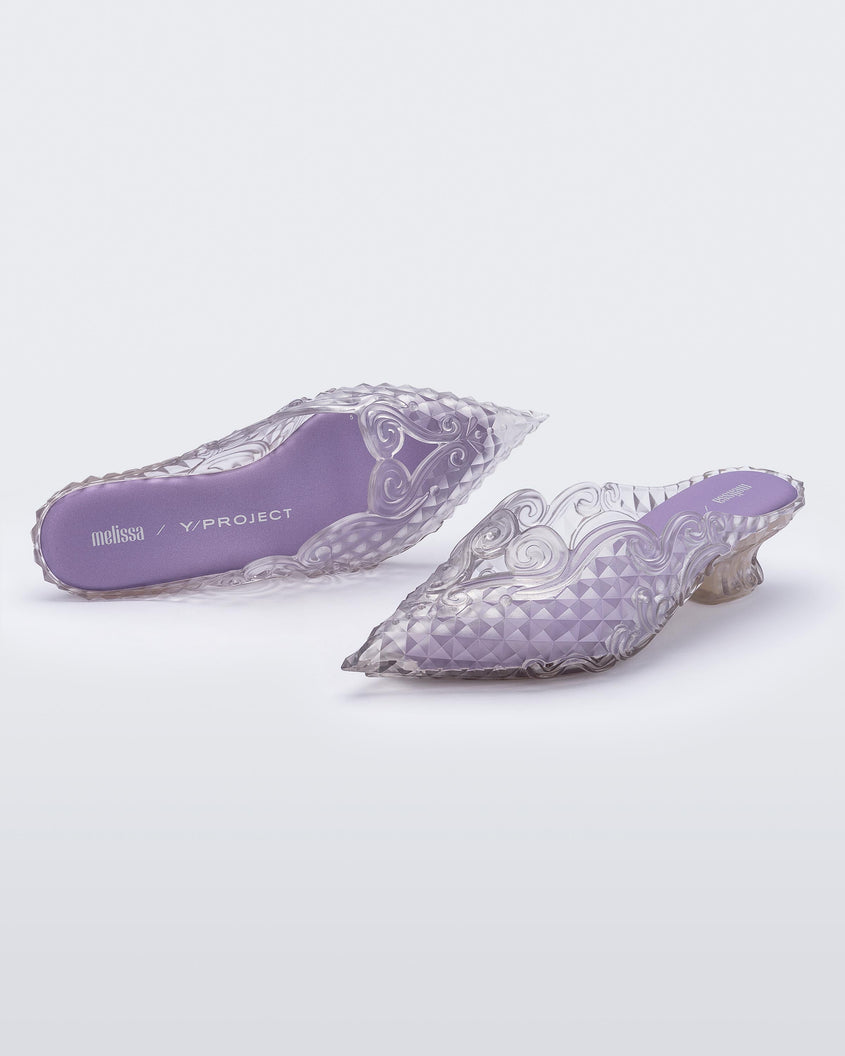 Top and angled view of a pair of Melissa Court mules in clear with a kitten heel and diamond- like pattern.