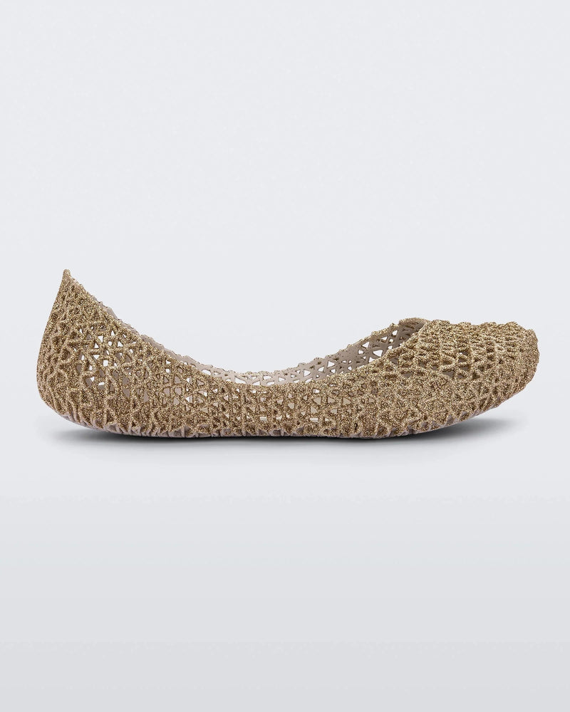 Side view of a white / gold glitter Mini Melissa Campana flat with an open woven texture.
